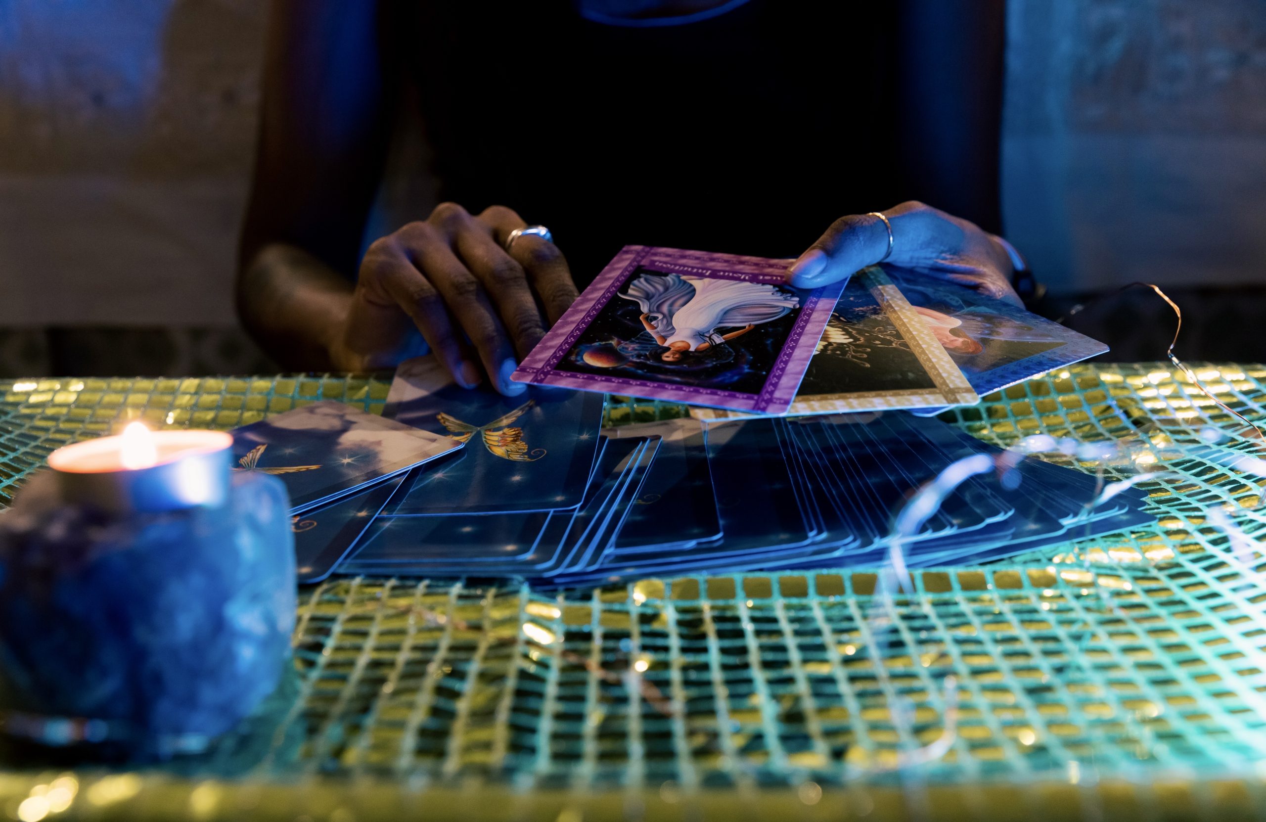 A woman is engaged in a card game, focused intently on her hand at a table.